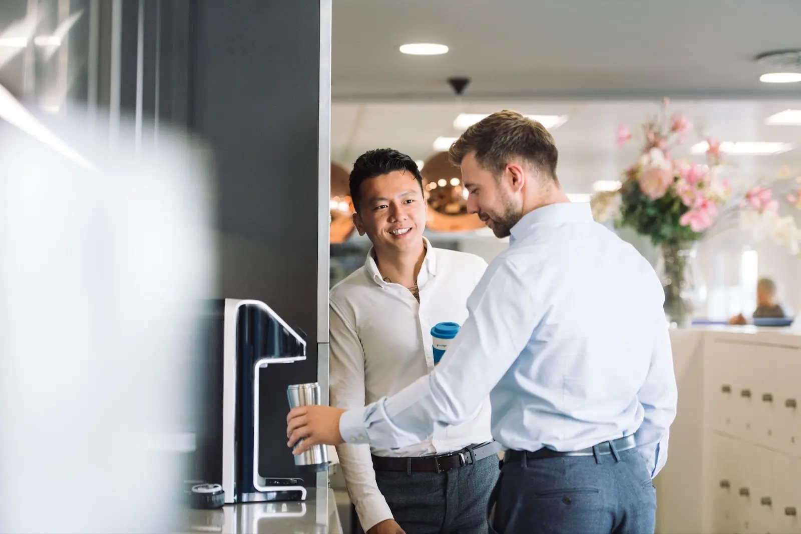 Hombres bebiendo agua de una máquina dispensadora de agua